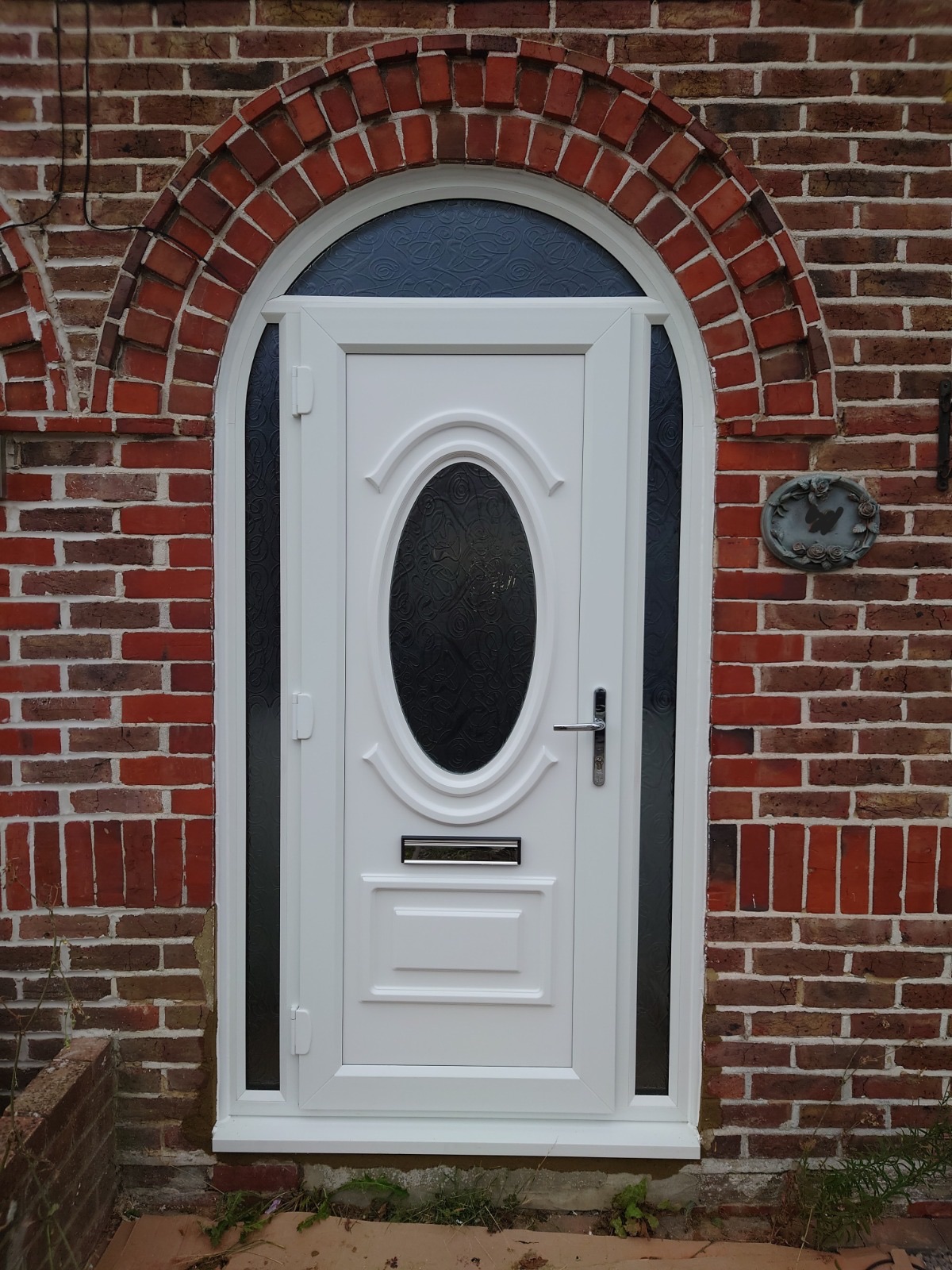 White uPVC door with an arched brick surround, fitted by HDS